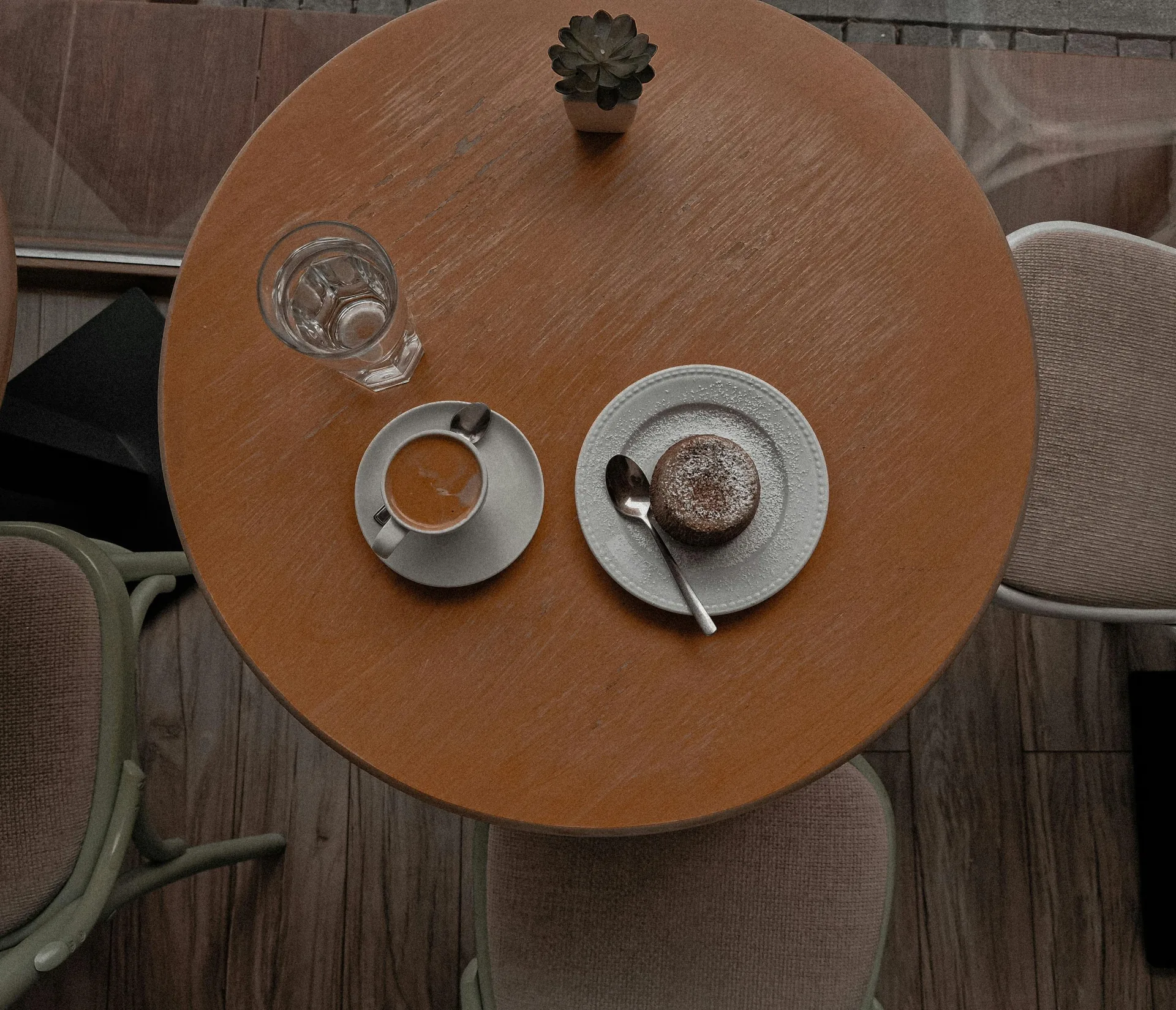 Cozy Melbourne cafe table from above with espresso and a small cake on a wooden surface